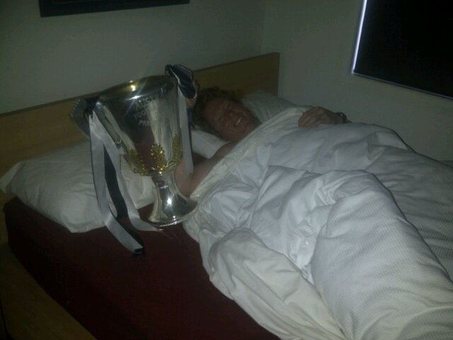 CAMERON LING WAKES UP WITH THE 2011 PREMIERSHIP CUP THE MORNING AFTER